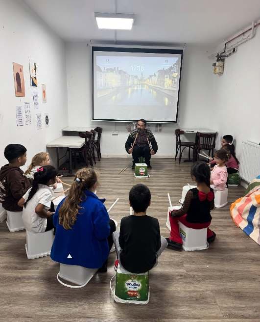 Children taking part in a guided drumming activity at UMW